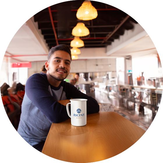 man sitting at counter with ascent bank mug